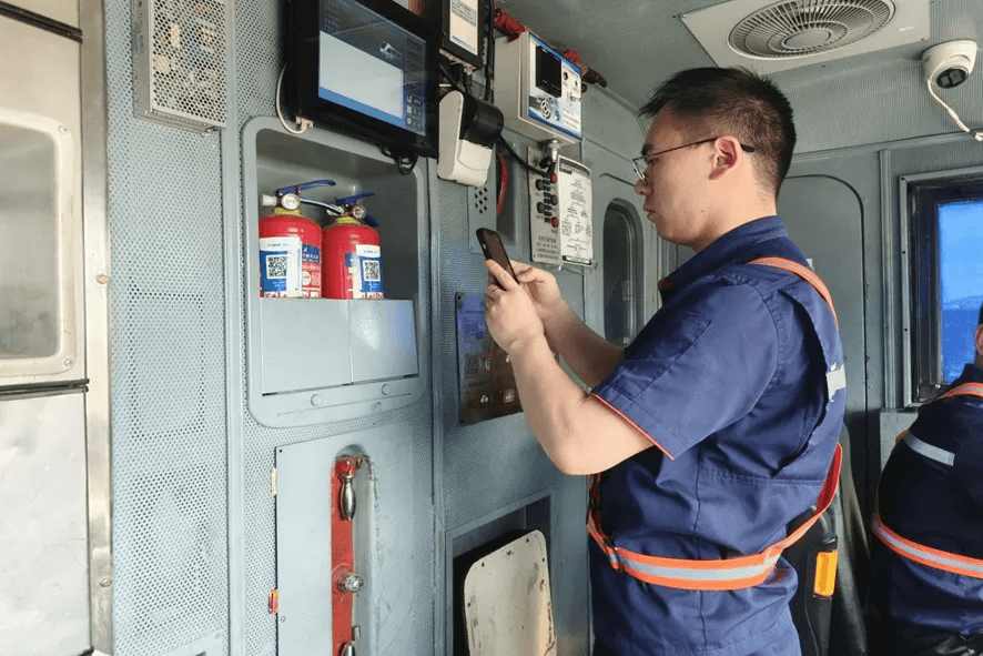 Staff scanning QR code to check locomotive fire extinguisher information