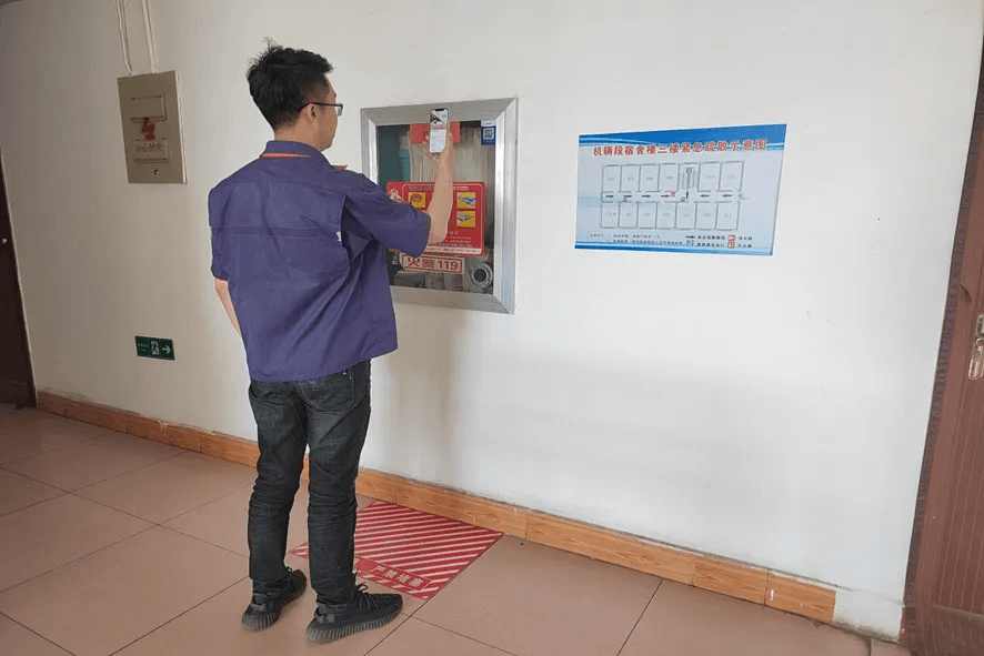 Management personnel scanning QR code to fill in inspection information after checking a fire hydrant